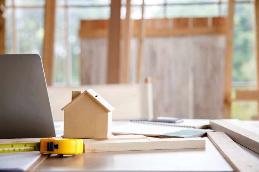 Concept of tiny house design with a wooden house and tools on table